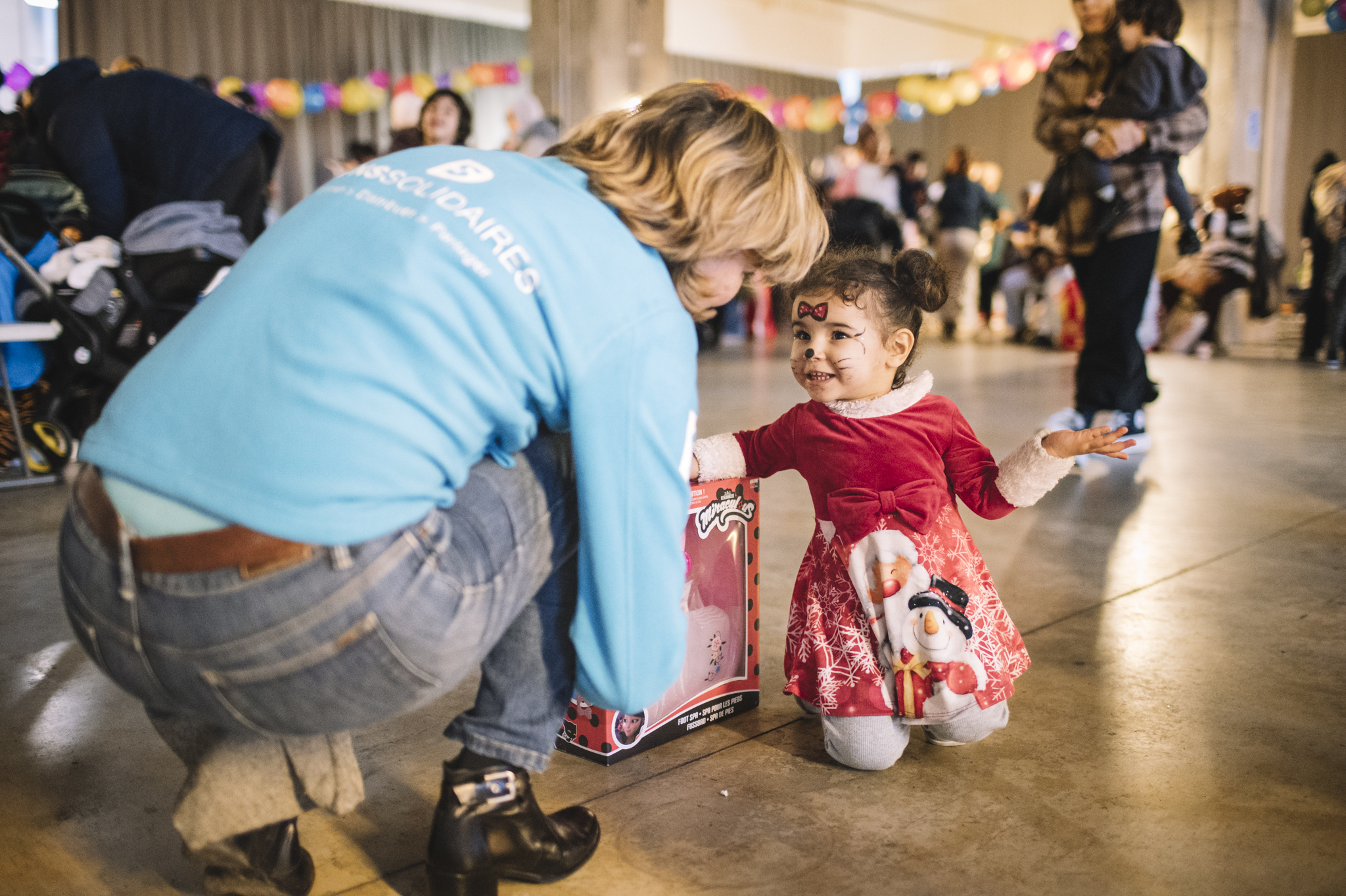 un membre de Dons Solidaires donne un cadeau à une petite fille